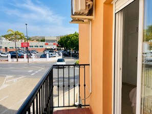 A balcony with a view of a parking lot and a building across the street. - Apartamento La Cala Blanc en La Cala del Moral (Rincon de la Victoria)
