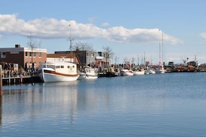 A marina with boats docked, a building with a sign, and a clear sky. - Holiday apartment with 1 bedroom (Heiligenhafen)