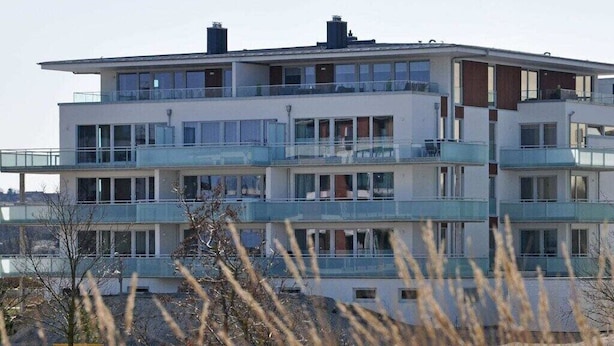 Un edificio residenziale a più piani con balconi, ampie finestre e un tetto piatto.
