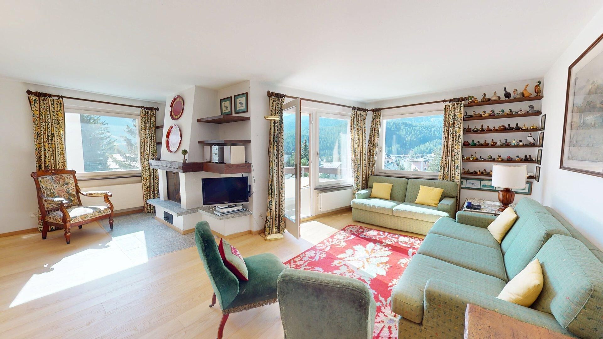 A living room with a sofa, armchair, TV, and decorative items.