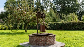 A sculpture of a person with a bell in a park.