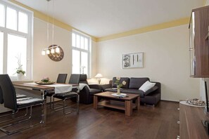 Una sala de estar con sofá, mesa de centro y comedor con sillas y una mesa.