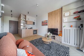 A modern living space with a kitchen, dining area, and a seating area with a sofa and coffee table. - Kierbedzia Comfort Stay, Mokotów, Warsaw (Warszawa)
