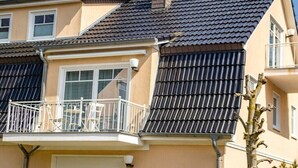Un immeuble résidentiel doté d’un balcon, d’une fenêtre et d’une porte.