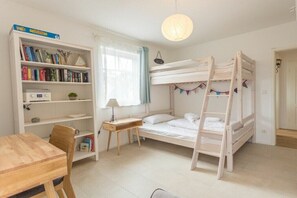 A bunk bed with a ladder, a desk, a chair, a bookshelf, and a window with curtains. - Holiday apartment F5 (Graal-Müritz)