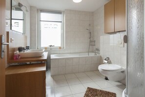 Une salle de bain moderne avec une baignoire, des toilettes et un lavabo.