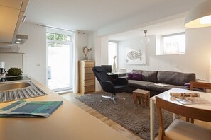 A modern living space with a kitchen, dining area, and seating area. - Holiday apartment in Norderney with Wi-Fi (Norderney)
