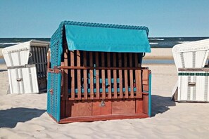 A beachside wooden structure with a blue roof, surrounded by wicker chairs. - in the lake park "Heringsdorf" (Heringsdorf (Seebad))