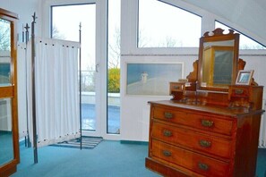 A room with a large window, a wooden dresser with a mirror, and a framed picture on the wall. - in the lake park "Heringsdorf" (Heringsdorf (Seebad))