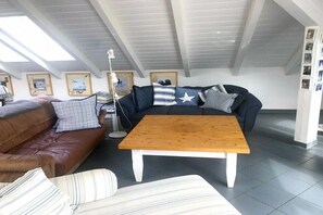 A modern living room with a brown leather sofa, a dark blue sofa with striped pillows, and a wooden coffee table. - in the lake park "Heringsdorf" (Heringsdorf (Seebad))