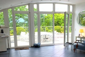 Une pièce dotée d’une grande porte-fenêtre coulissante donnant sur un patio extérieur.