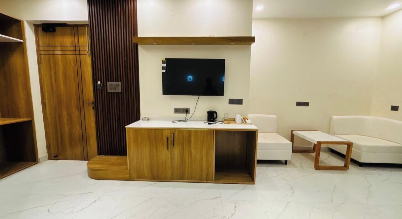 Un salon moderne avec un meuble en bois, un téléviseur à écran plat, un canapé blanc et une table basse.