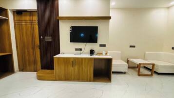 Un salon moderne avec un meuble en bois, un téléviseur à écran plat, un canapé blanc et une table basse.