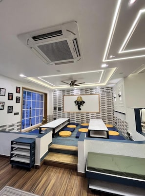 Un interior moderno con una zona de estar central, un ventilador de techo y una pieza decorativa montada.