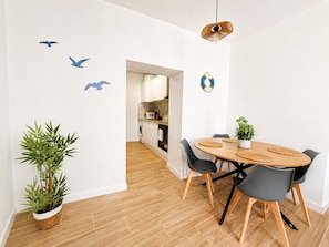A modern dining area with a round table, chairs, and a potted plant. - Torrox Village House (Torrox)