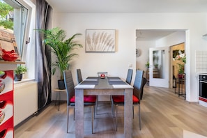 Un comedor moderno con una mesa, sillas y una planta en maceta.