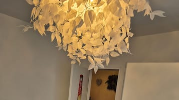 A bedroom with a bed, a wardrobe, a door with a beer bottle decal, and a ceiling light fixture.