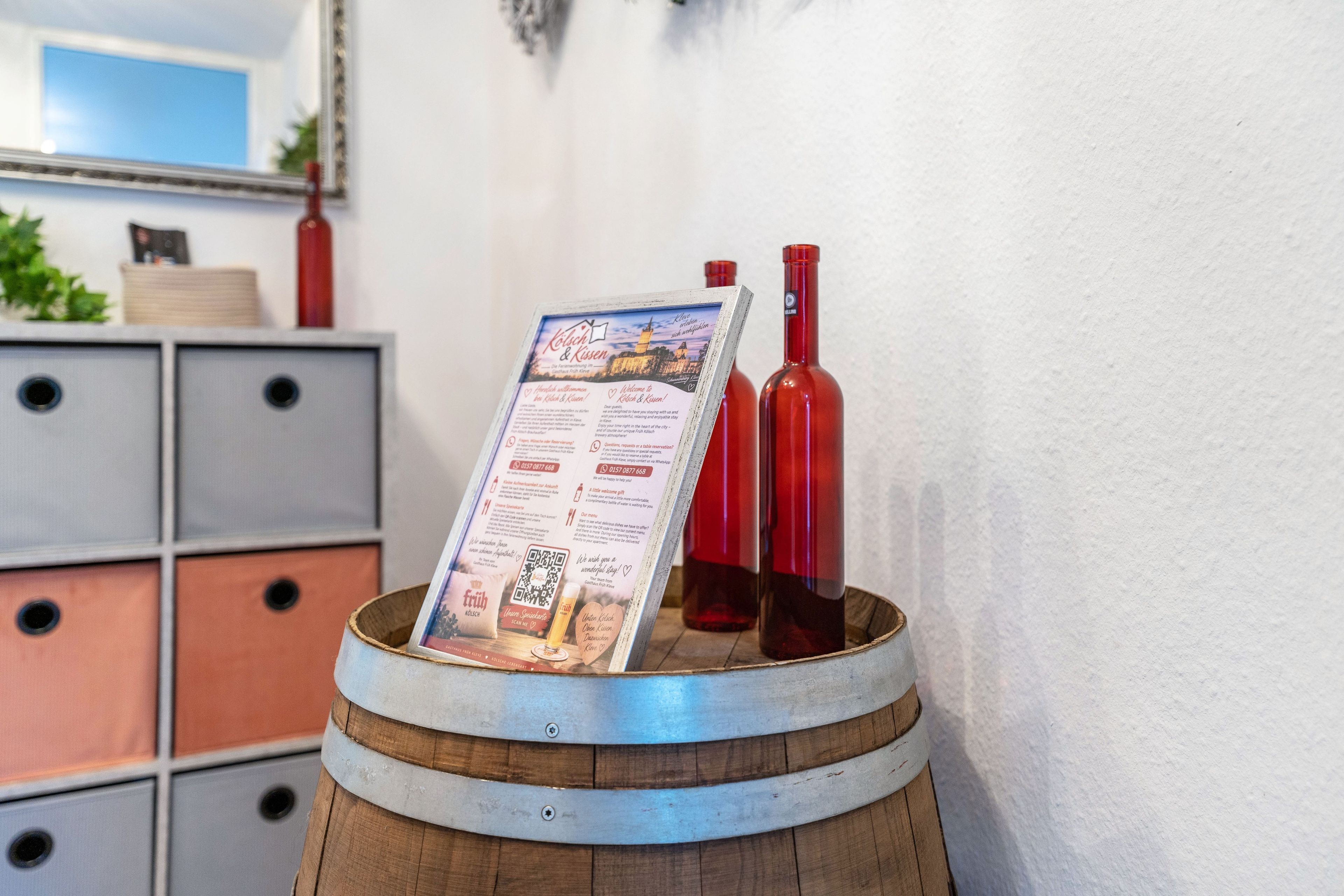 Un barril de madera con un menú y dos botellas de vino tinto.