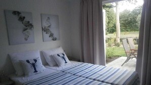 A bedroom with a bed, two pillows with a lobster design, and two wall art pieces. - Holiday home with 2 bedrooms (RB Hulshorst)
