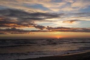 A sunset over the ocean with clouds in the sky. - Holiday home with 3 bedrooms (Julianadorp aan Zee)