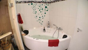Un baño moderno con una bañera independiente, ducha y pared de azulejos con diseños circulares.
