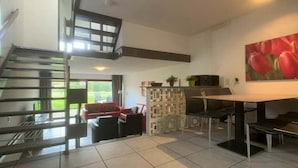 Un interno moderno con una scala, una zona pranzo e un'area living.