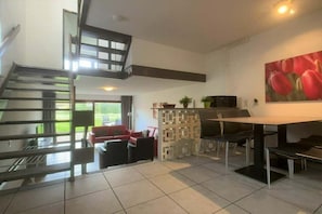 A modern interior with a staircase, a dining area, and a living space. - Wijk de Brabander 58 (Cadzand)