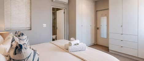 A bedroom with a bed, a wardrobe, and a bathroom door.