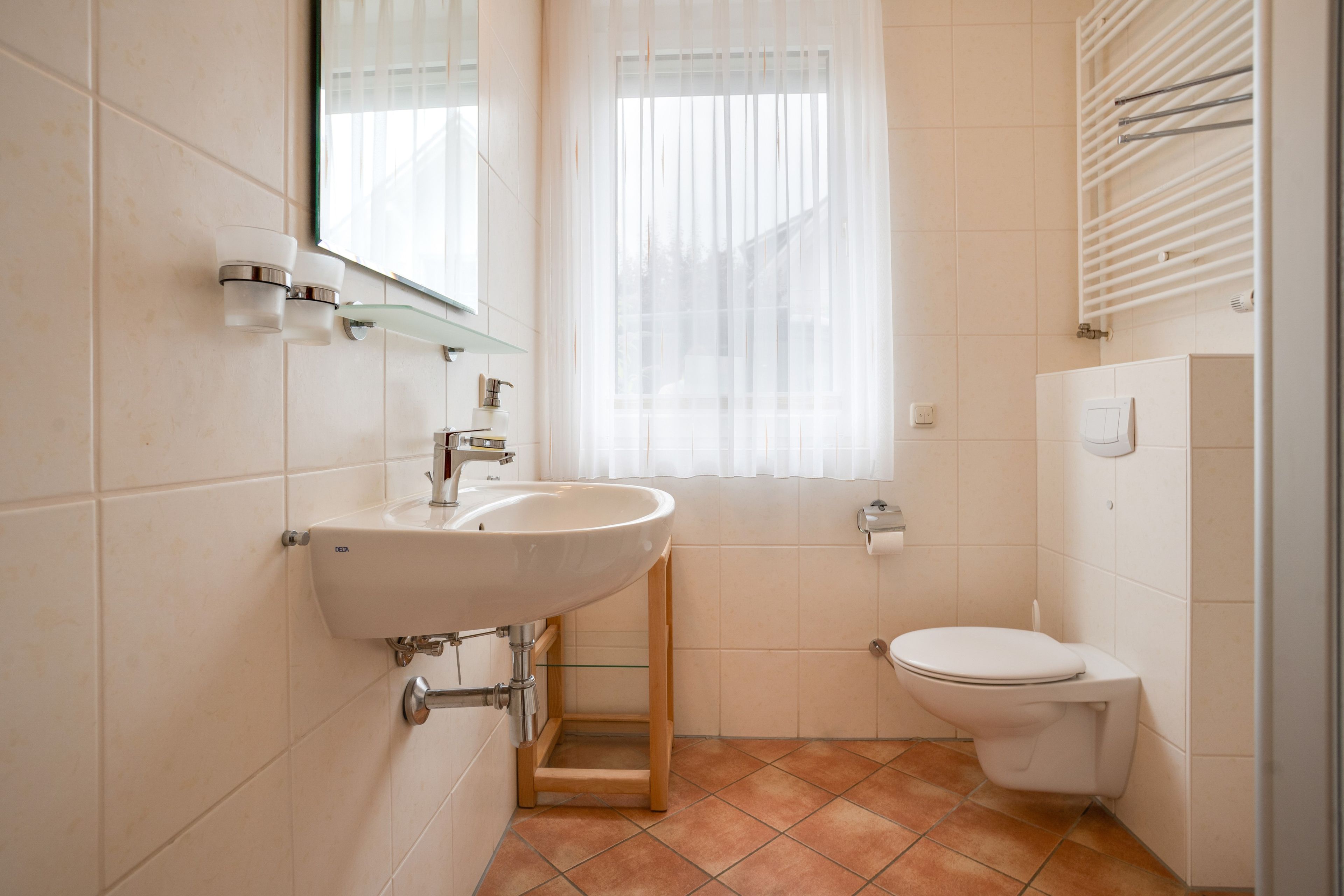 A bathroom with a white sink, a toilet, and a shower area.