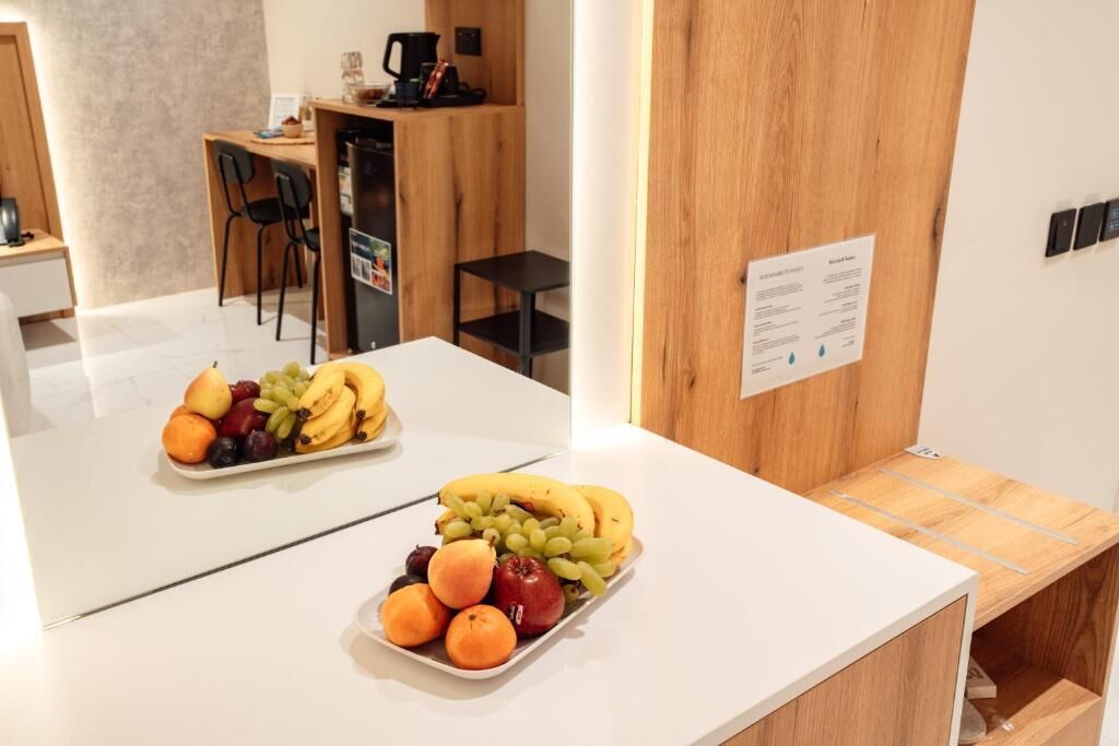 Quarto de hotel com uma mesa branca, um armário de madeira e um aviso na parede.