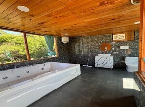 A modern bathroom with a large bathtub, a marble sink, and a wooden ceiling. - Latos Chapter Sajwar (Banjar)
