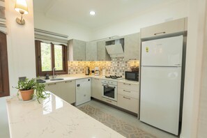 A modern kitchen with a built-in dishwasher, a refrigerator, a stove, and a sink. - Beach Suite L Penthouse İcmeler (Muğla)