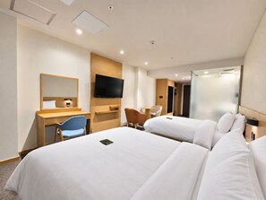 Een hotelkamer met twee bedden, een bureau, een stoel, een televisie en een kledingkast.