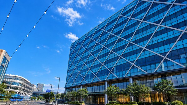 Een modern gebouw met een glazen gevel en een geometrisch ontwerp.