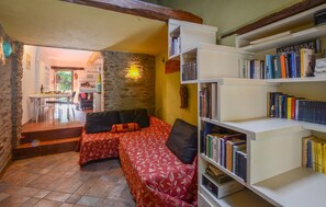 A cozy living area with a sofa and a bookshelf filled with books. - 1 bedroom cozy home in Levigliani (Levigliani)