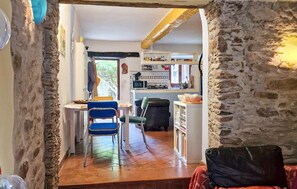 A narrow hallway leading to a kitchen with a dining area, stone walls, and a view of the outdoors. - 1 bedroom cozy home in Levigliani (Levigliani)