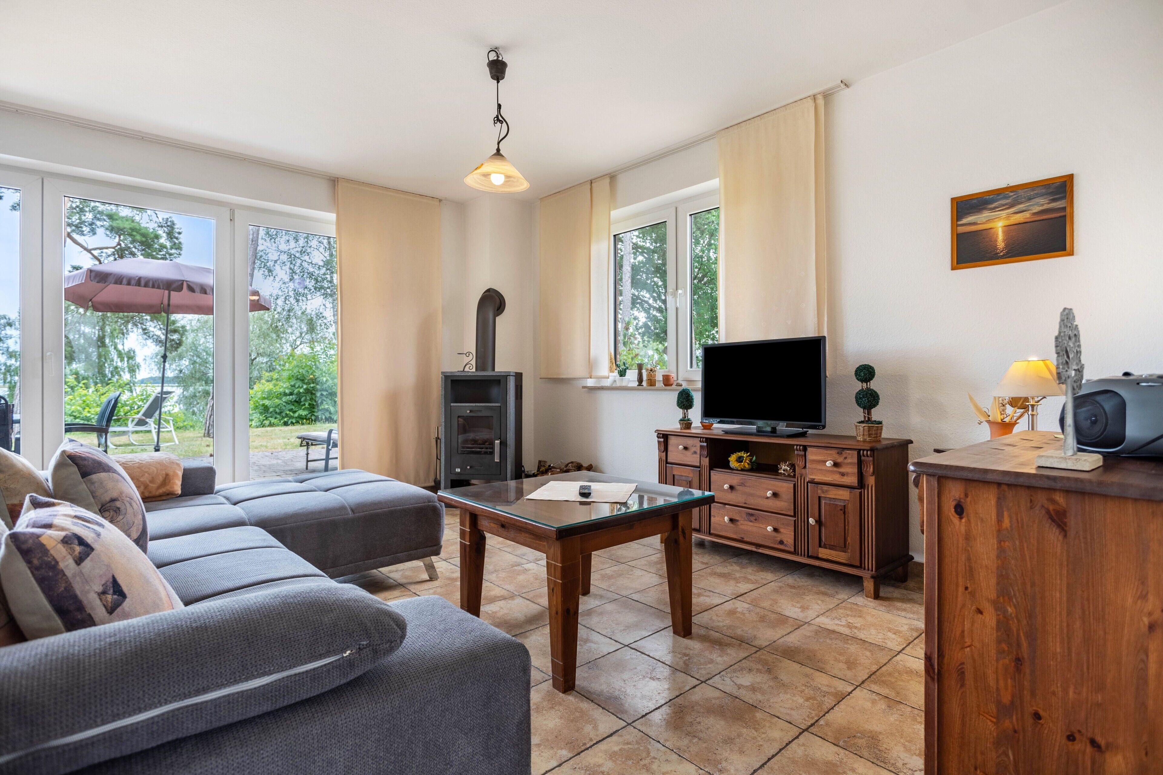 Ein modernes Wohnzimmer mit einer Couch, einem Glastisch, einem Fernseher und einem Kamin.
