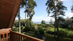 Eine Holzterrasse mit Blick auf eine grüne Landschaft und Bäume.