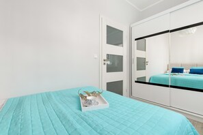 Ein Schlafzimmer mit einem Bett, einem Kleiderschrank und einem Nachttisch mit Tablett.