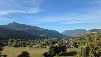 A rural landscape with a village, mountains, and a golf course.
