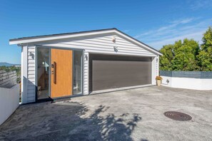 Un garage moderne doté d’une porte coulissante, d’une porte de garage et d’une allée en béton.