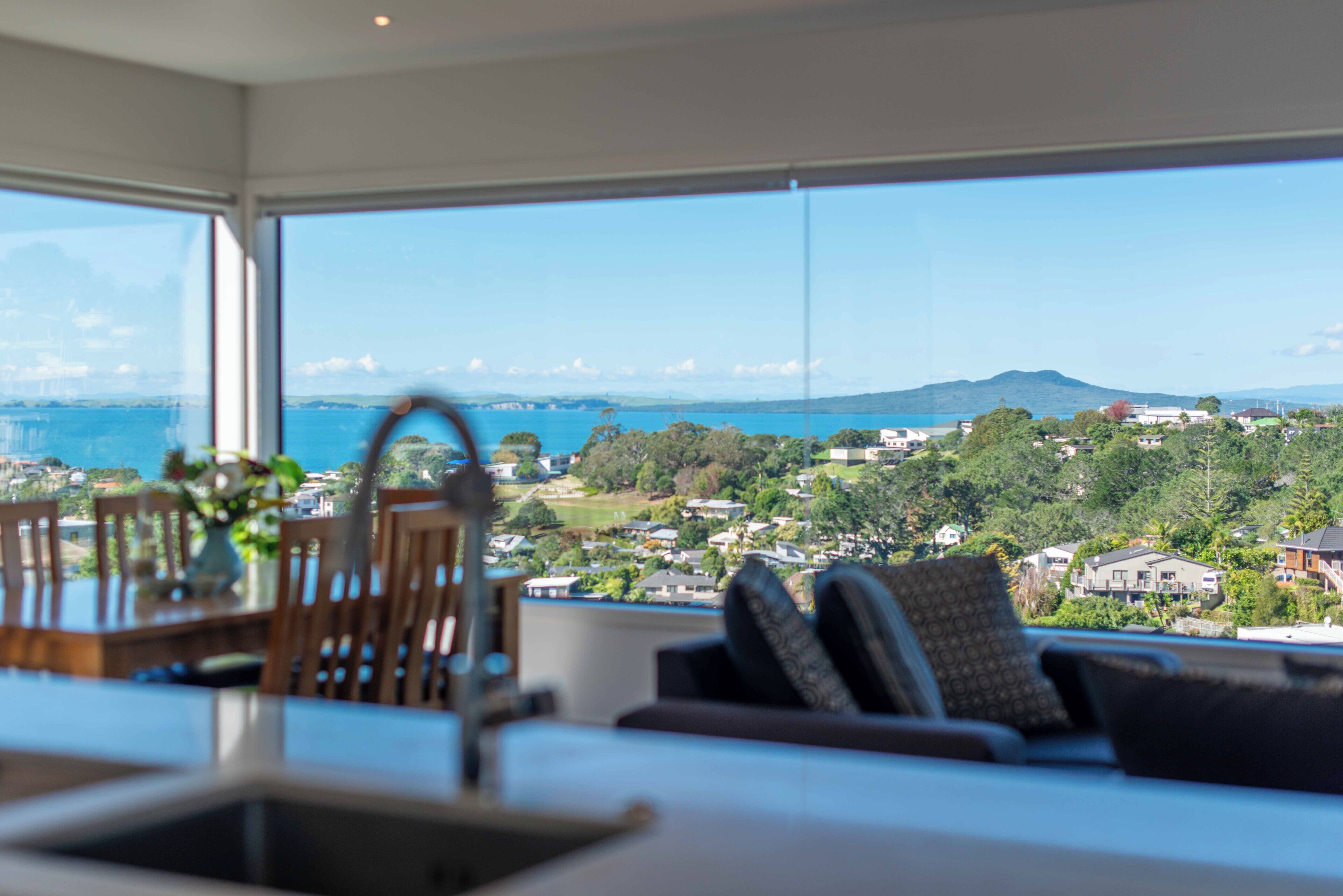 A modern living room with a view of a coastal landscape.