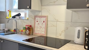 A kitchen with a built-in stove, a coffee machine, and various kitchen items on the counter. - Chatham 5-bed House, Sleeps 10 w/ Parking & Garden (Chatham)