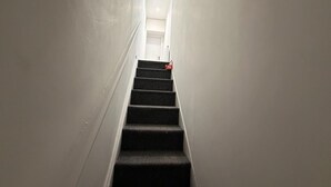 A narrow, carpeted stairway leading to a door at the top. - Spacious 5-bedroom Home in Chatham With Private Garden Sleeps 7 (Chatham)