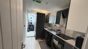 A modern kitchen with a built-in oven, a sink, and a stove. - Spacious 5-bedroom Home in Chatham With Private Garden Sleeps 7 (Chatham)