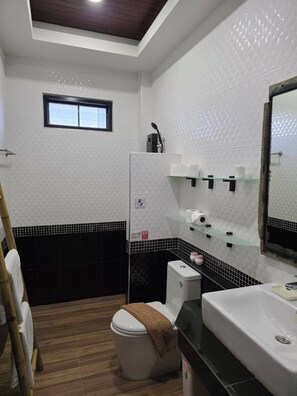 Een badkamer met toilet, wastafel en douche.