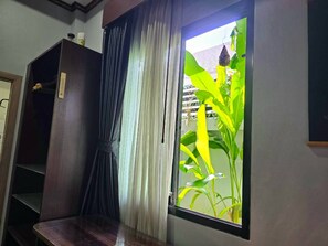 A room with a window, a wooden cabinet, and a curtain.