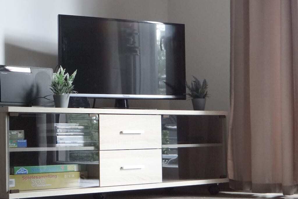 Ein Fernseher auf einem Schrank mit Schubladen und einer Pflanze.