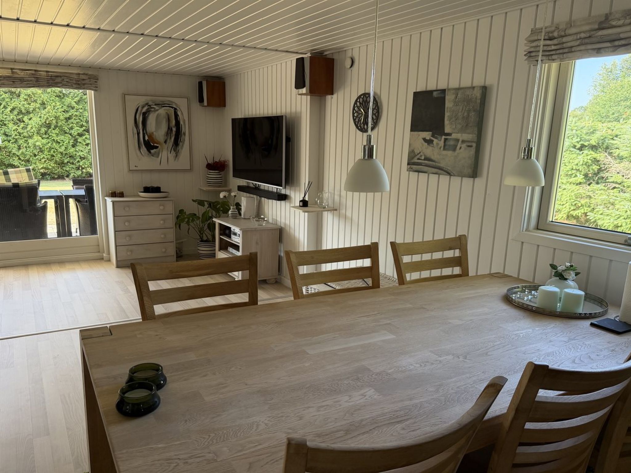 Comedor con mesa de madera, sillas y televisor.