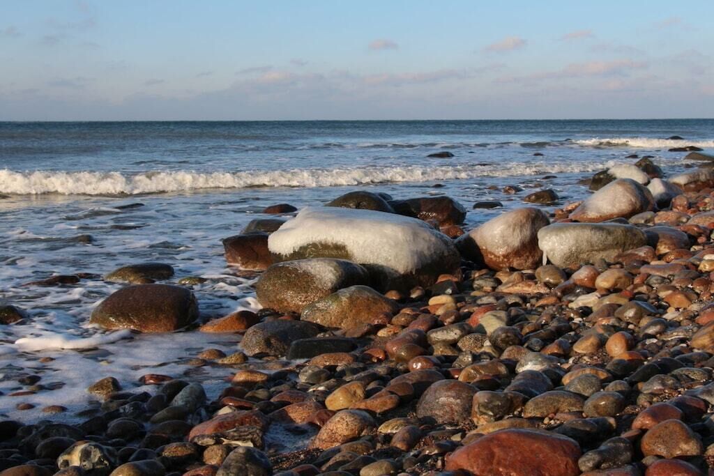 A rocky beach with waves gently lapping at the shore.